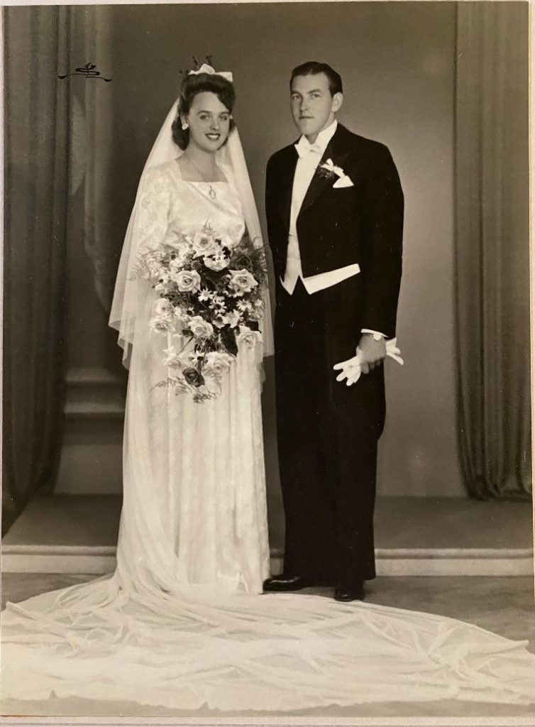 1940s vintage wedding photo of a 1940s bride with her groom in a tuxedo. Stunning 1940s wedding dress and 1940s vintage hairstyle