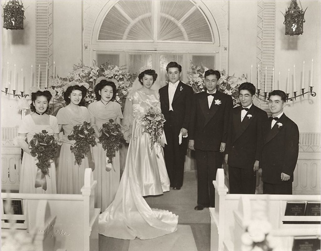 A 1940s wedding photo of a Japanese-American bride and groom with their wedding party, Los Angeles, CA. Oh my...so many things to love in this photo! From the perfect 1940s hairstyles and the stunning floral bouquets to the hats on our bridesmaids and our handsome groom in his tux. And that Tiara on our bride!