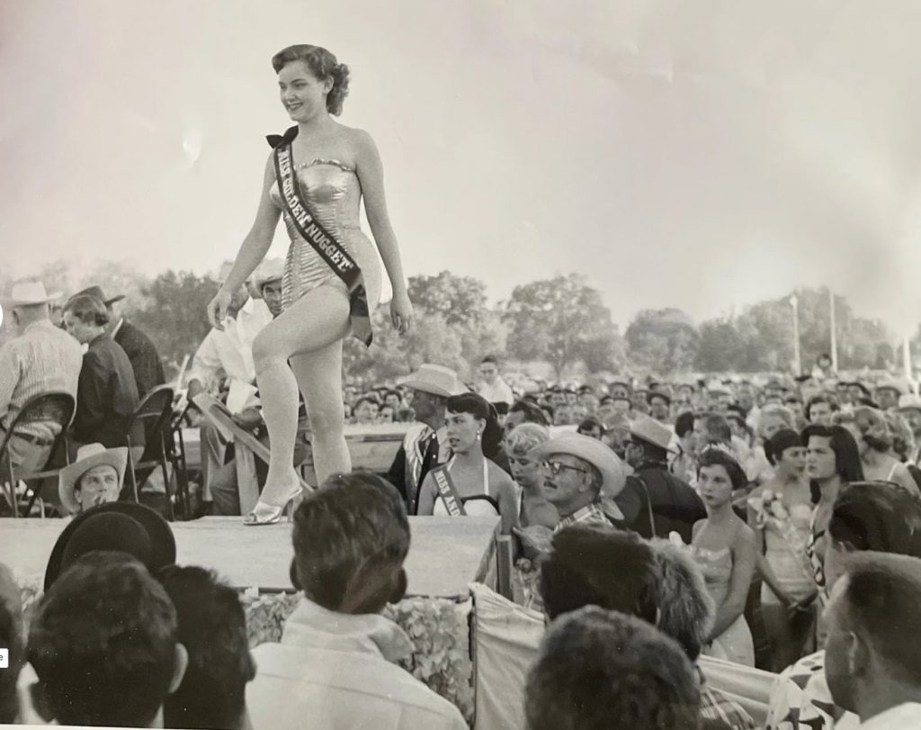 1950s Photo: Beauty contestant "Miss Golden Nugget", Las Vegas in a bathing suit takes the stage while other contestants and audience look on.