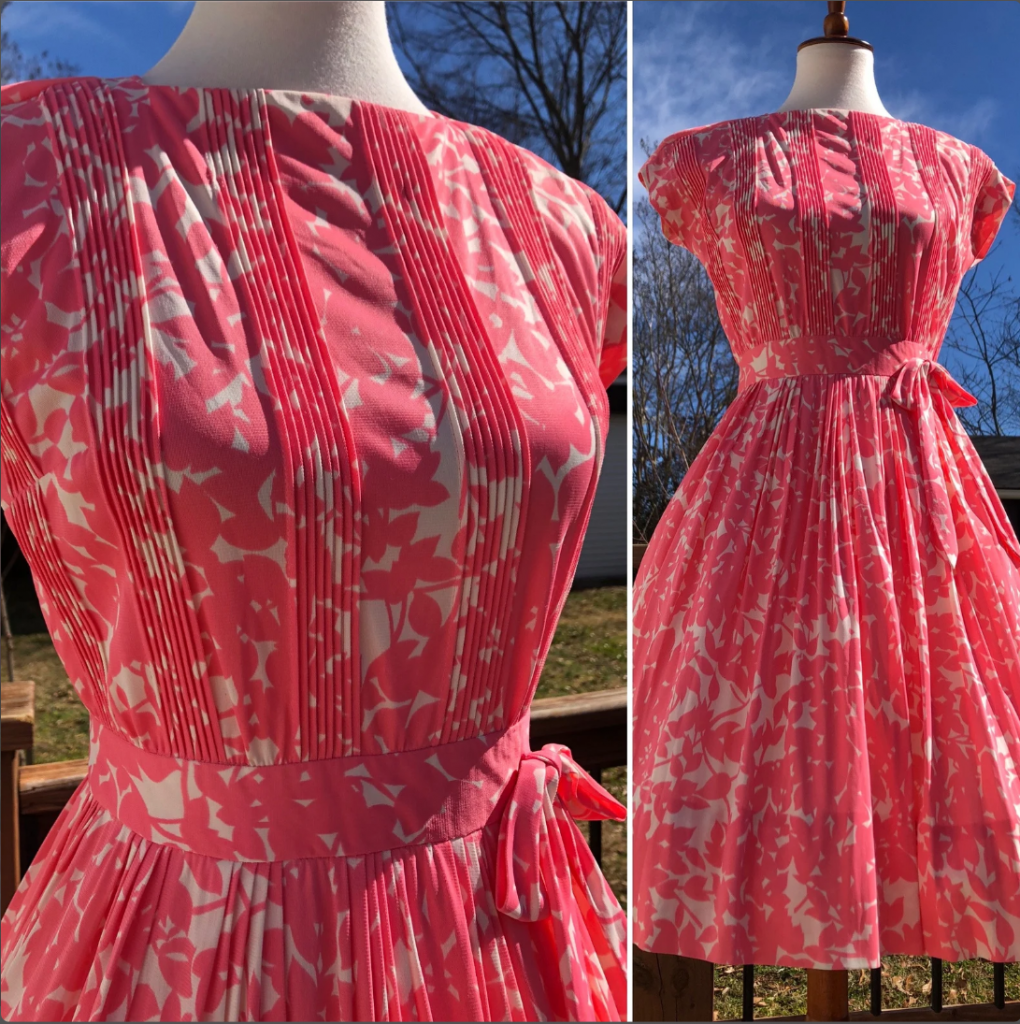 1950s Fashion: Flamingo Pink Floral L'Aiglon Dress from the 1950s. Bright pink floral against a white background. 6 Groupings of vertical pleats on the bodice. Waistband has attached bow above pleated skirt. Perfect Vintage Summer Outfit. 