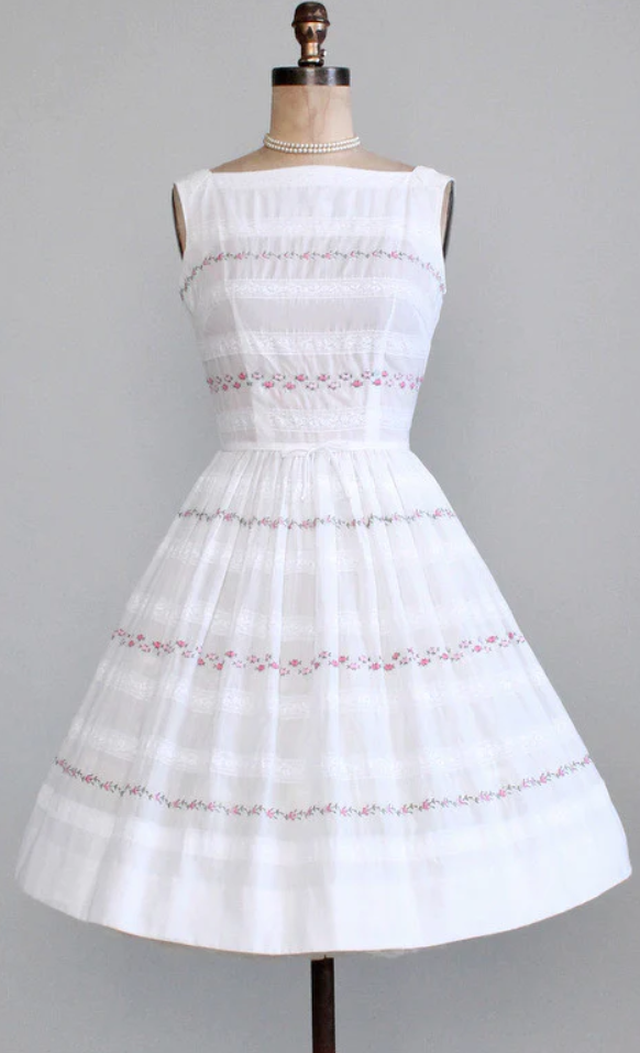 1960s Fashion: A very sweet early 1960s sundress by L'Aiglon!  Lightweight, slightly sheer white cotton/polyester blend.  Stripes of lace and tiny embroidered pink roses.  Classic silhouette with a fitted bodice and full, gathered skirt.