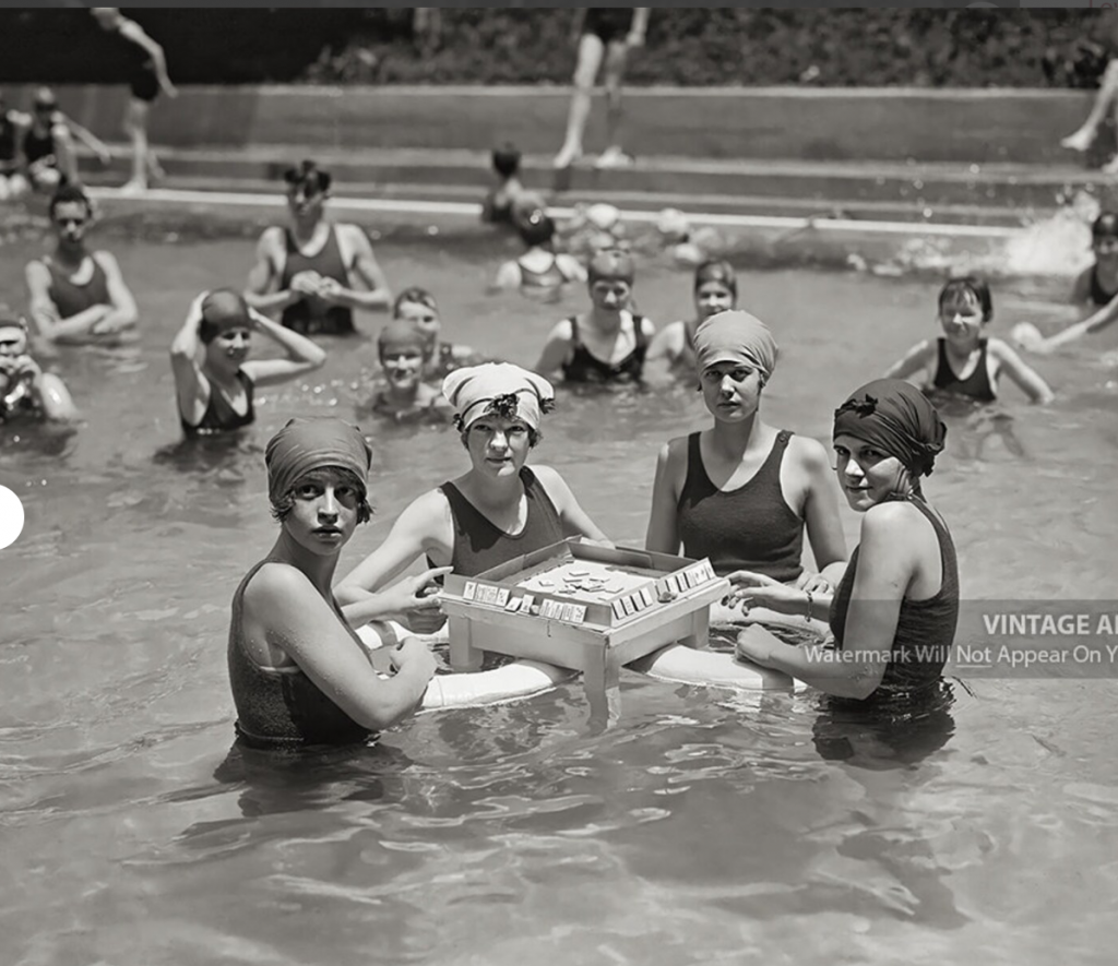 1920s vintage photo of 1920s Bathing Beauties Playing Mah-Jong in a Swimming Pool in their 1920s bathing suits. 