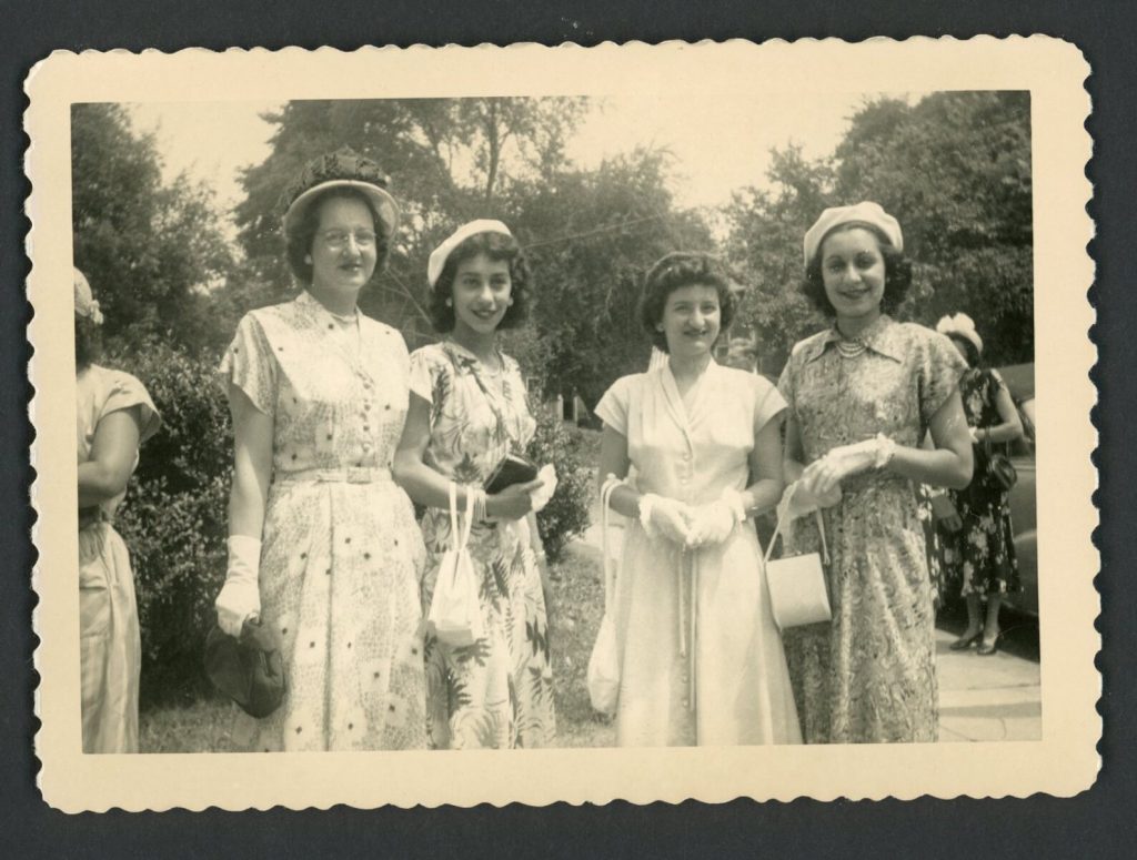 1940s vintage photo of 4 women in 1940s fashions posing together at a Garden party - 1940s patterned & floral summer dresses with hats and handbags