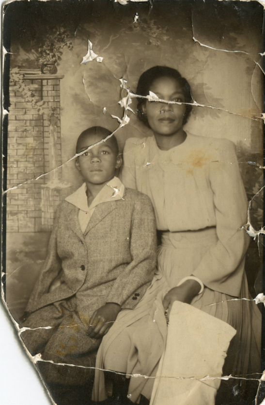 1940s vintage photo booth image of a pretty Black mother with her son in a suit.