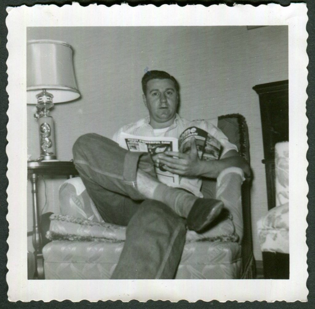 1950s vintage photo of a man sitting in his favourite armchair reading 'Home Craftsman'.