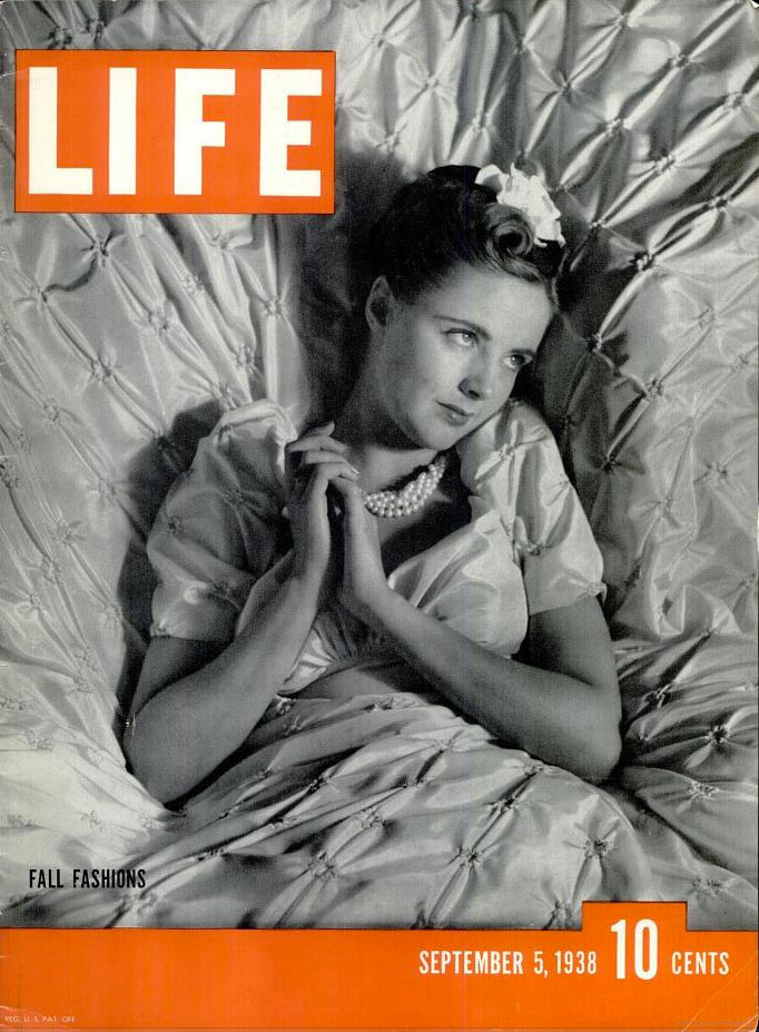 LIFE Magazine September 5th, 1938: A lovely young woman is all set to dream about 'Fall Fashions' as she poses in a fancy nightgown and pearls with a pretty late 1930s hairstyle (complete with hairflower).  