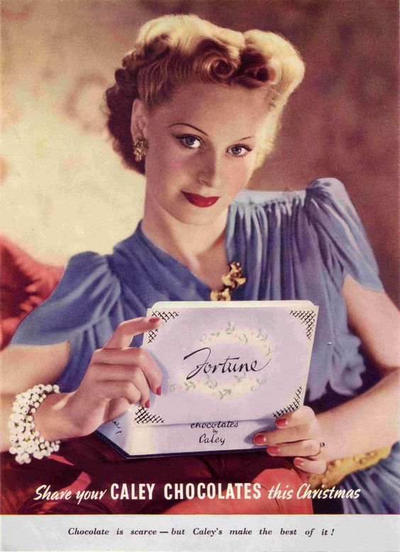 1940s vintage advertiing for Caley chocolates featuring a woman with a 1940s hairstyles and 1940s makeup and jewelry holding a box of chocolates