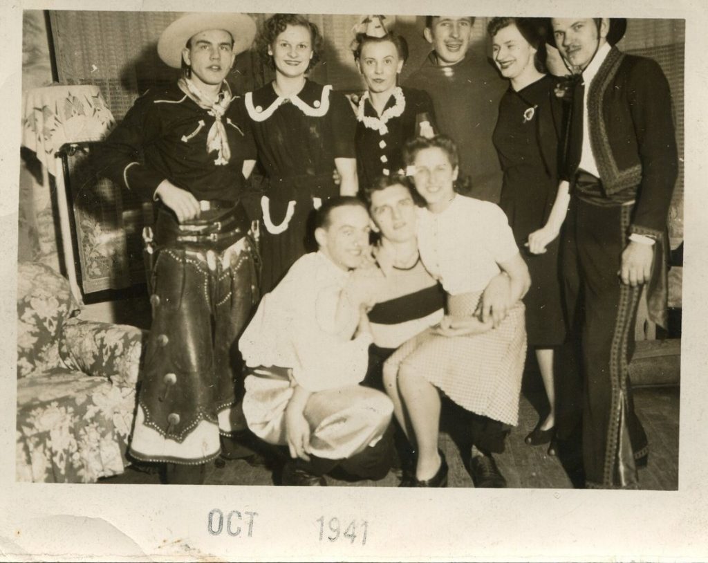 1940s vintage photo of a adult Halloween party from October 1941 featuring a man dressed as cowboy, women as maids, spanish man, a bee and ladies with fantastic 1940s hairstyles. 