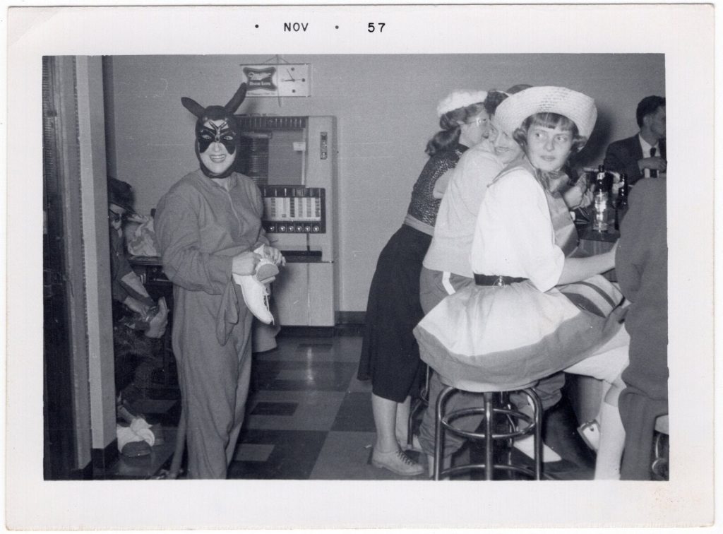 1950s vintage photo of people dressed up in Halloween costumes at a diner.