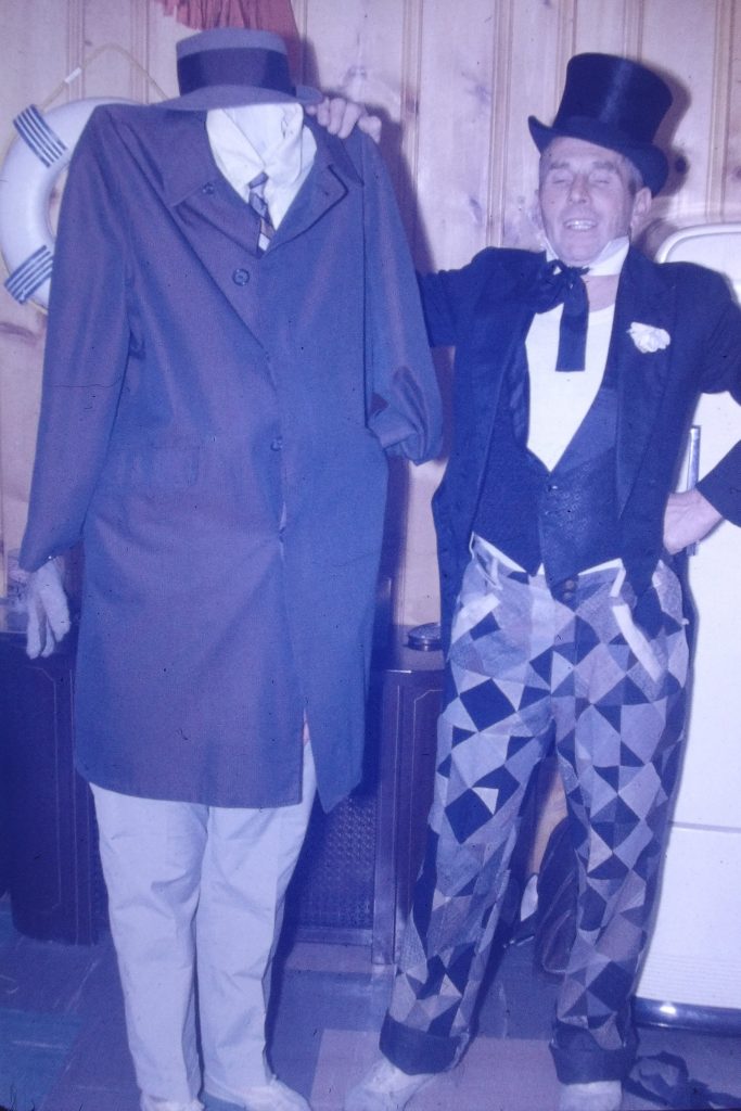 1960s vintage photo of The invisible man and a top hot wearing happy go lucky fancy dressed man at 1967 Halloween party. 