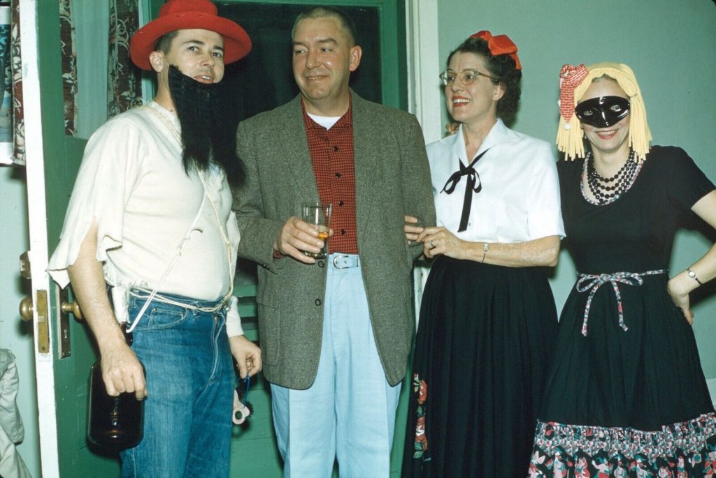 1960s Halloween party vintage photo featuring a hillbilly, and two lovely ladies in cute costumes. Everyone is so happy and having a good time it looks like. 