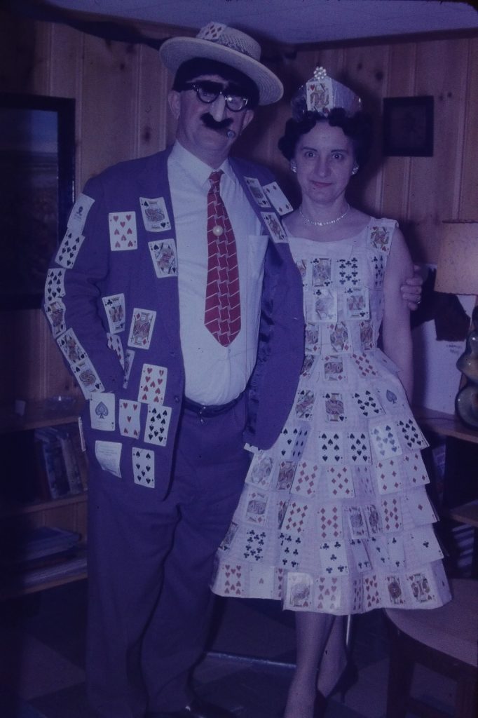 1960s vintage photo from 1967 of a Adult Halloween party featuring couples in vintage halloween costumes, like this couple covered in playing cards.