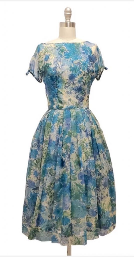 1950s Fashion: Darling vintage 1950s classic Vicky Vaughn fit and flare style dress in 2 layers - blue floral acetate/nylon with matching blue floral nylon chiffon overlay.