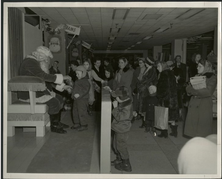 1950s vintage photo of kids visiting Santa Claus in a department store in 1955