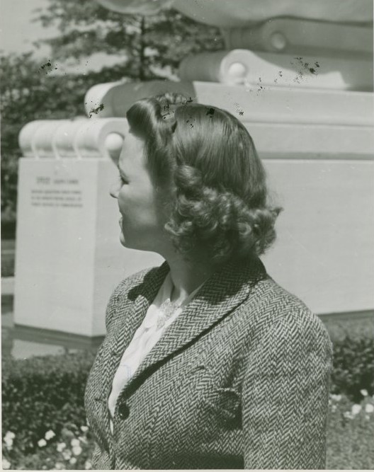 1940s vintage photo: A woman in 1940 at the New York World's Fair at the 'World of Fashion' Exhibit showing off a 1940 hairstyle (the back) with beautiful sculptured curls. 