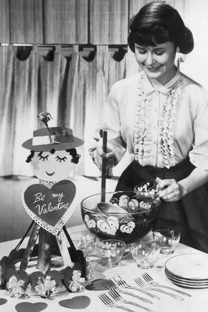 1950s vintage photo: 1957 photo of a young woman serving punch in the cutest punch bowl with fun & kitschy Valentine decorations.