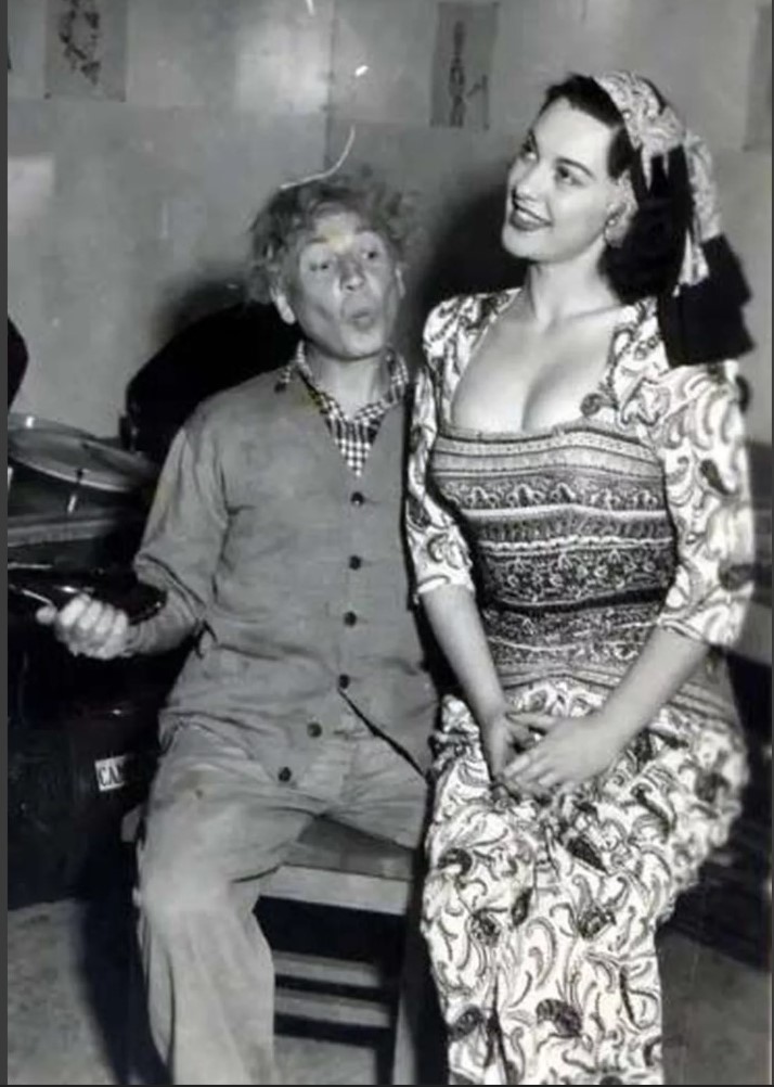 1940s vintage photo of Juli Lynne Charlot (the creator of the poodle skirt), wearing a dress of her own design, with Harpo Marx.