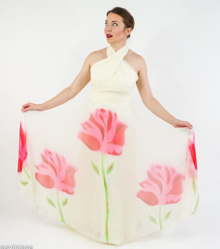 1950s Fashion: A 1950s Fred Perlberg elegant ivory silk chiffon halter gown with large flowers on the fabric.