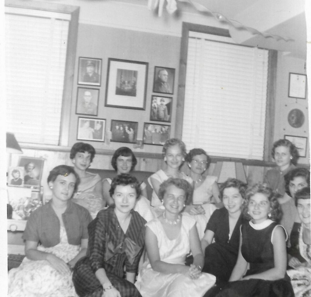 1950s vintage photo of a 1955 bridal shower featuring a group shot of the guests with the bride to be in 1950s dresses