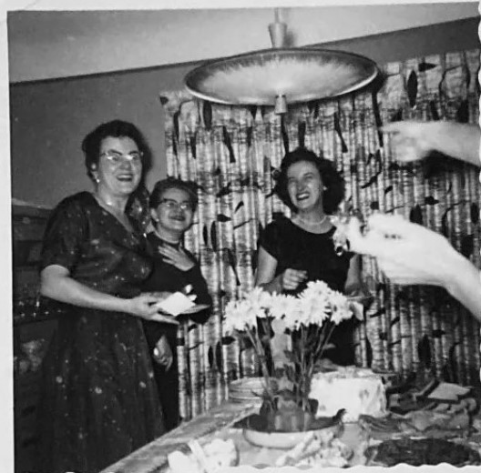 October 1955 Bridal Shower vintage photo. The 1950s vintage image features the bride to be and her guests in fantastic 1950s dresses and a super barkcloth curtains in the diningroom