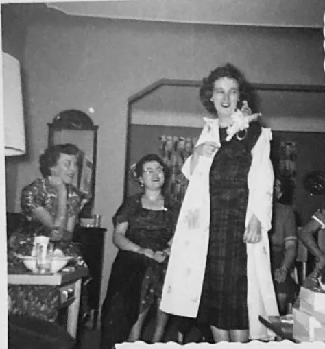 October 1955 Bridal Shower vintage photo. The 1950s vintage image features the bride to be taking off her coat to prepare for the party