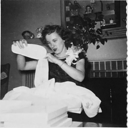 October 1955 Bridal Shower vintage photo. The 1950s vintage image features the bride to be opening her gift of slippers.