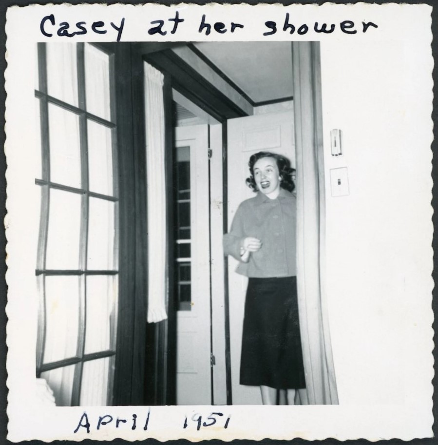 1950s vintage photo of a young woman in April 1951 at her bridal shower looking surprised while standing in the doorway in early 1950s fashion