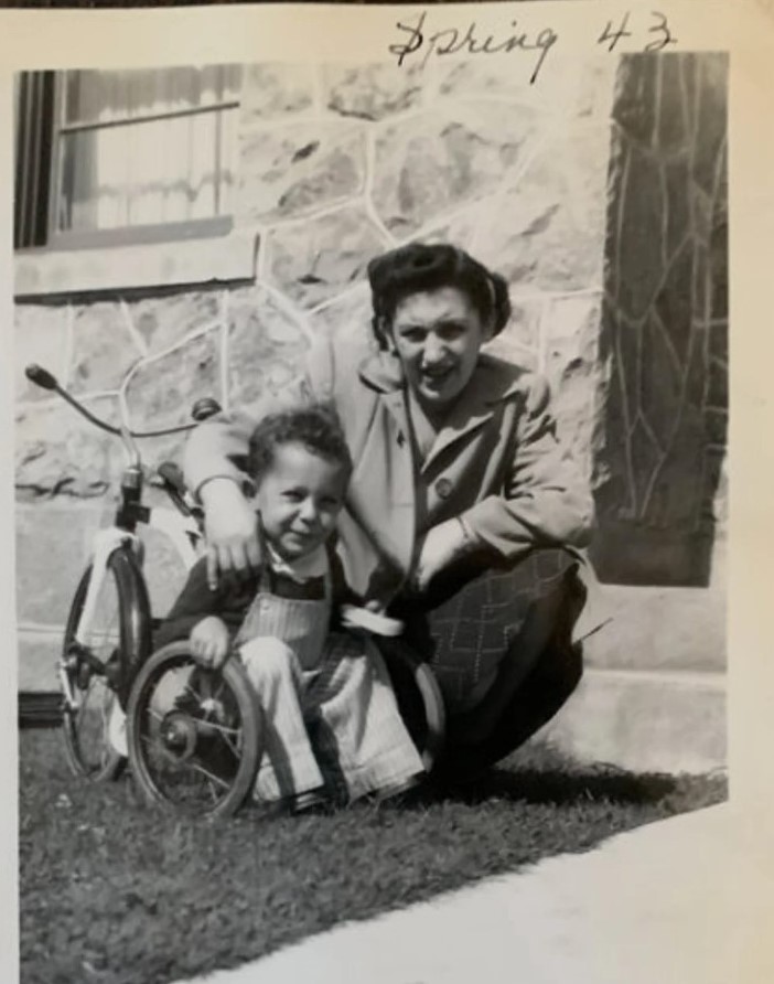 1940s vintage photo from 1943 of a mother with her son and his tricycle