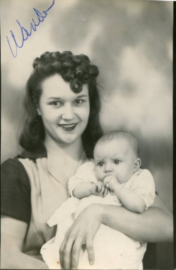 1940s vintage photo of a young mother with a head full of curls holding her little baby. Fantastic 1940s hairstyle inspiration