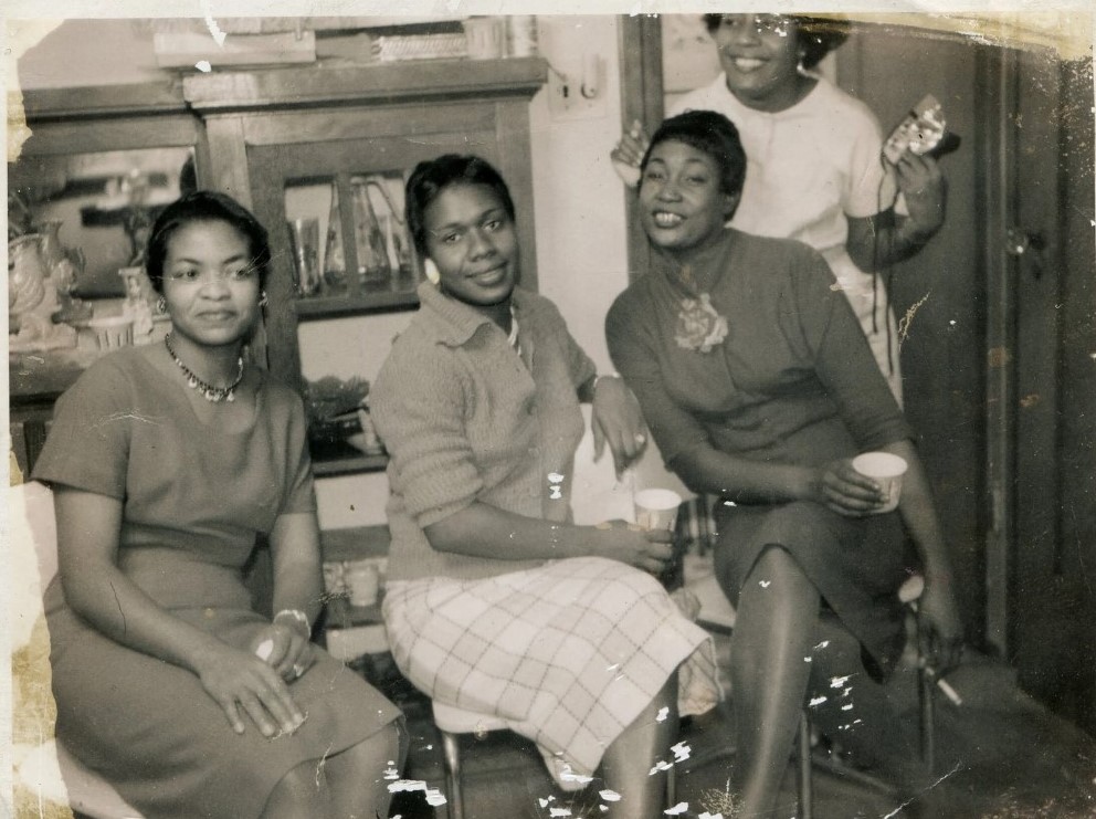 1950s vintage photo of 4 Black Women drinking out of dixie cups posing together in 1950s fashions and 1950s hairstyles