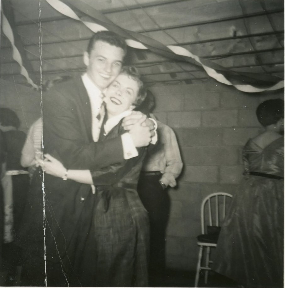 1950s vintage photo of a young couple hugging at a party with streamers