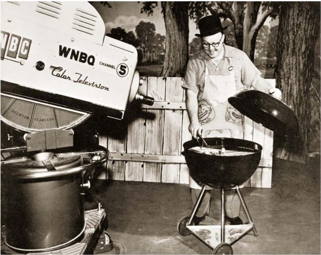 1950s vintage photo of a man in a hat demoing Weber grills on television.