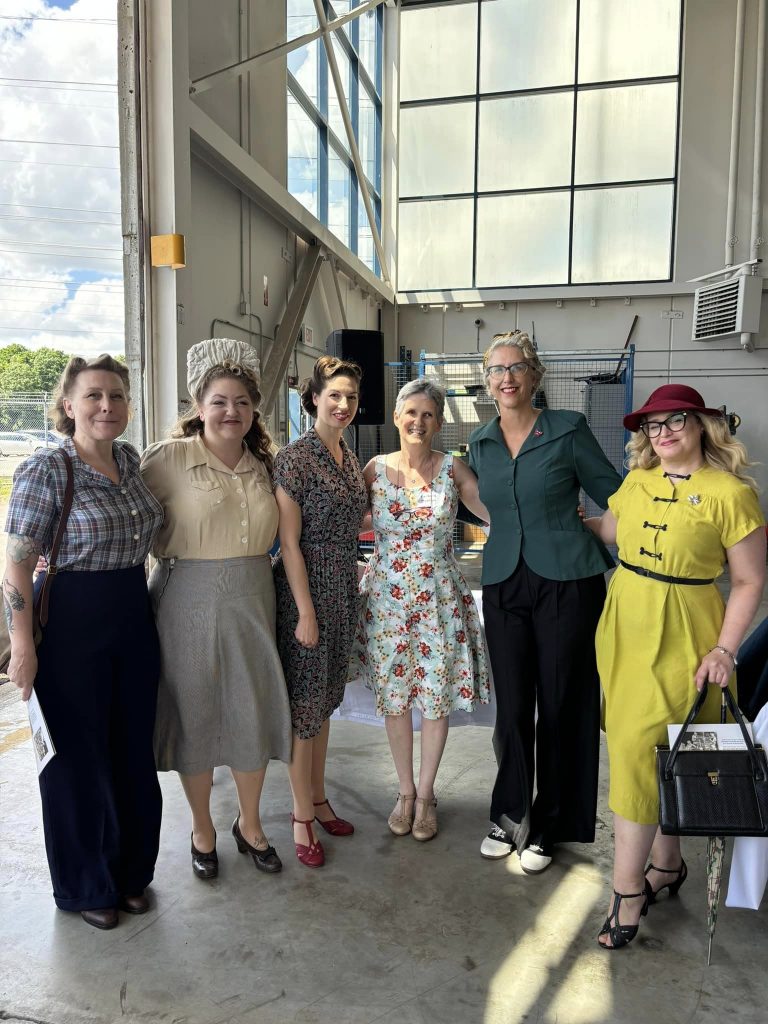 Bomb Girls of Scarborough memorial banner event June 2024 featuring the Toronto Vintage Society in 1940s fashions with the author of Bomb Girls-Trading Aprons for Ammo, Barbara Dickson.