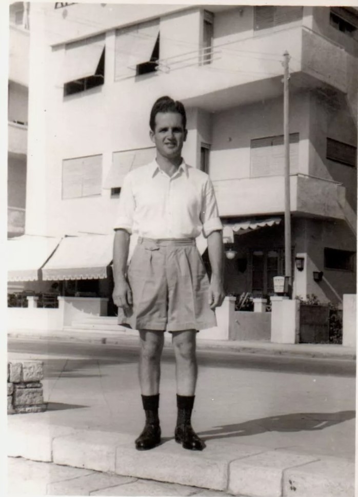 Mid century photo 1950s 1960s of man in shorts standing on the street