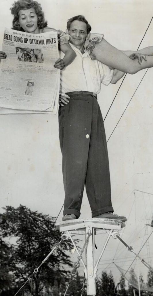 1940s vintage photo from Toronto's Canadian National Exhibition-1947 photo. Daredevils Aerialists, Betty and Benny Fox, brother and sister, are a breath-taking feature at the C.N.E. They are seen reading an edition of The Star on their 18-inch-wide platform. Highest paid air artists, they get $375 daily. 