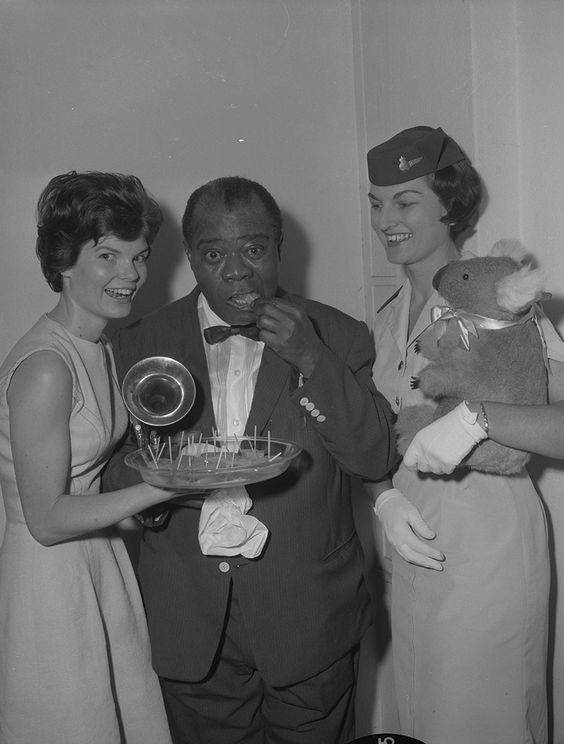 1950s vintage photo: Louis Armstrong and his Koala buddy enjoying some taste testing at the 1954 CNE (Canadian National Exhibition in Toronto). The woman holding the stuffed Kola Bear is a flight attendant.