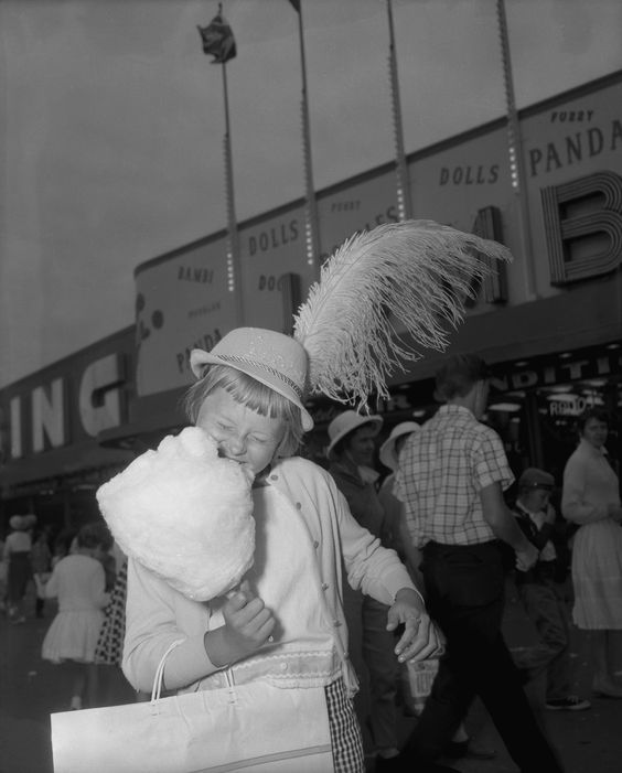 1960s vintage photo from Toronto's CNE Canadian National Exhibition youth day in 1961 featuring a young girl eating cotton candy in a Bavarian hat