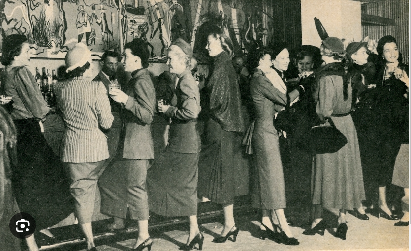 1940s vintage photo of women in 1940s fashions 'Storming the Sazerac' at The Roosevelt Hotel in 1949. ABOUT: Only men were served in the hotel’s classy Sazerac Bar—except for Mardi Gras day —but in 1949, a group of local women were thirsty and looking for sustenance. They stormed the Sazerac Bar demanding equality and a stiff drink.