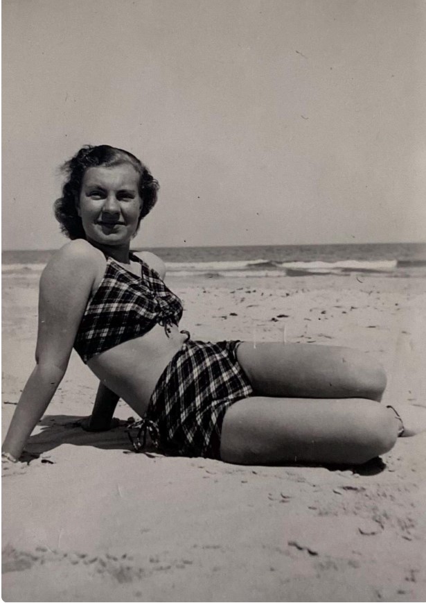 1930s photo of a woman in a plaid two piece swimsuit in 1935 on the beach.