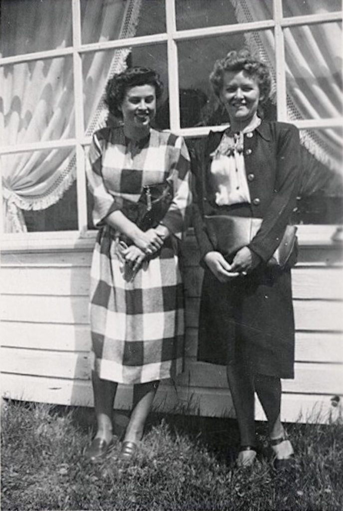  1940s photo of 2 women posing outside in their going out outfits (1940s fashions). Our lady on the left is sporting a lovely plaid dress while her friends in a cute two piece suit with blouse. Big fan of the 1940s hairstyles.