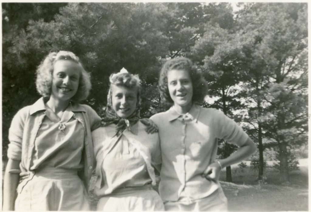 1940s vintage photo of 3 young girls in cardigans and 1940s hairstyles posing together with smiles outside. Fun 1940s fashions & 1940s vintage hairstyle inspiration