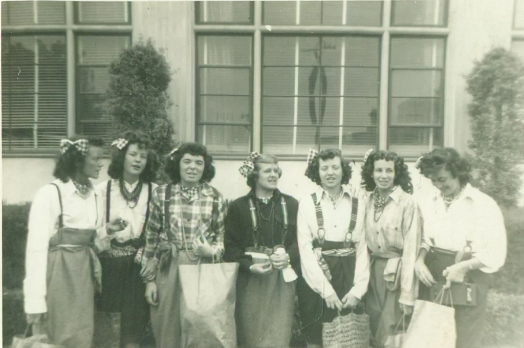 1940s vintage photo of a group of girls wearing matching plaid bows in their hair and seem to be all wearing some sort of costume. Fantastic 1940s hairstyle inspiration.