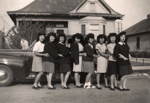 1940s vintage photo of 'The Just Us Girls club in Los Angeles in 1946' at UCLA. A group of stylish Japanese American Young Women in skirts, sweaters and cardigans and saddle shoes.