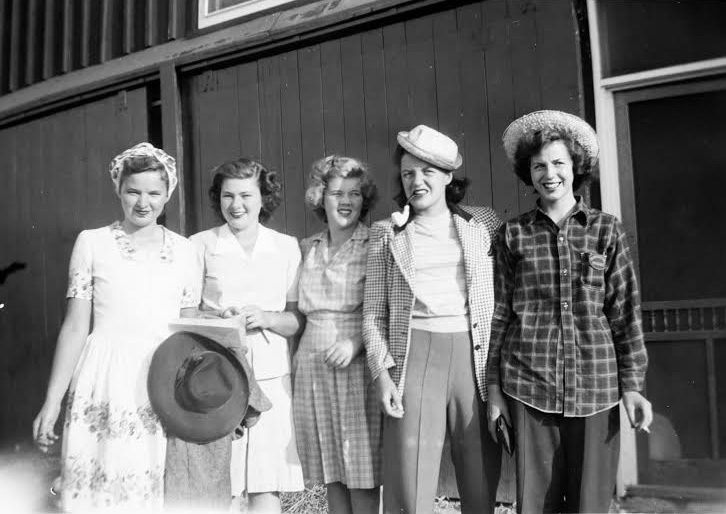 1940s vintage photo of a group of women dressed up to go out after working on a Farm in Ontario Canada to help feed Canadian soldiers during ww2. They were called Farmerettes. Fantastic 1940s fashions!