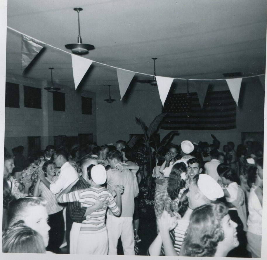 1950s vintage photo of sailors and other men and women at dance, dancing together and having fun together. 