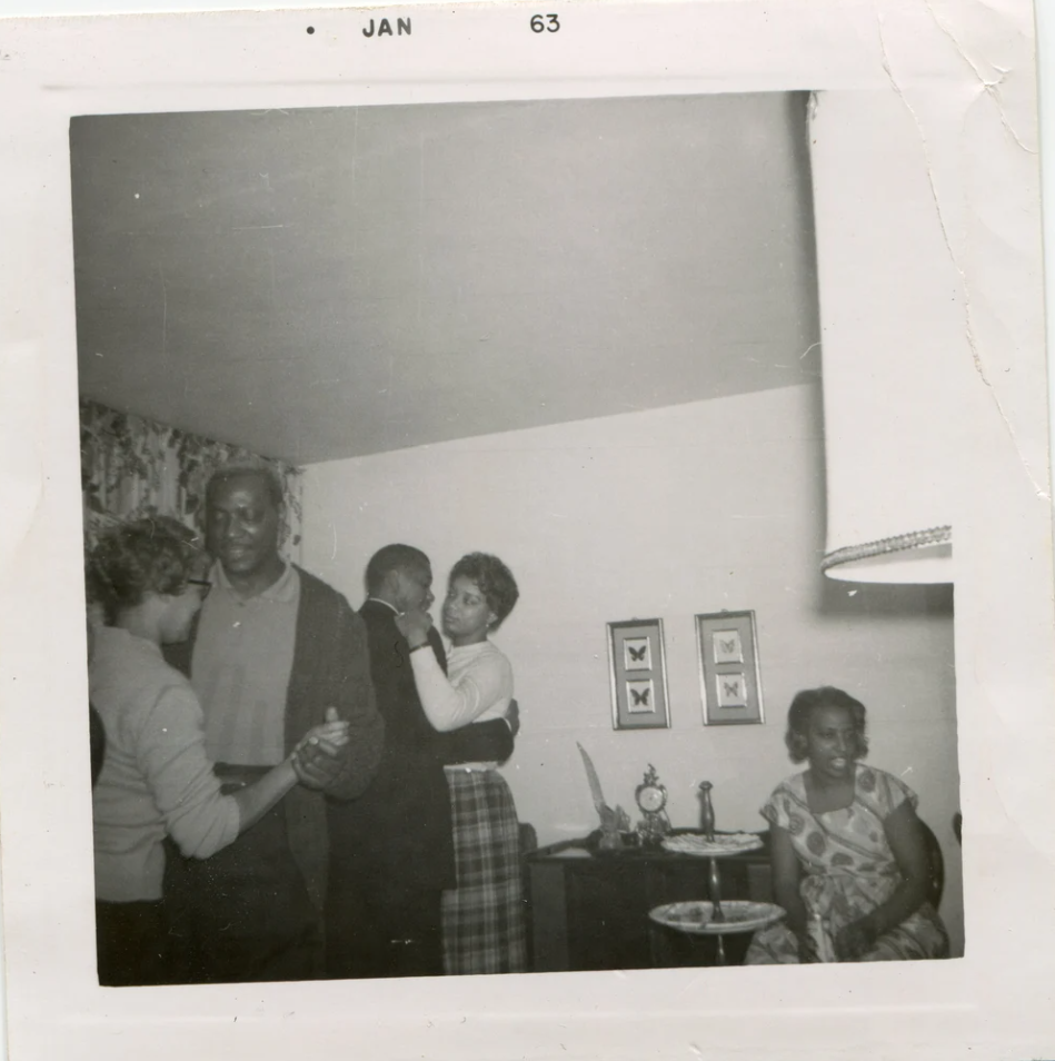 1960s vintage photo of Black Men & Women slow dancing in a living room party -January 1963. 