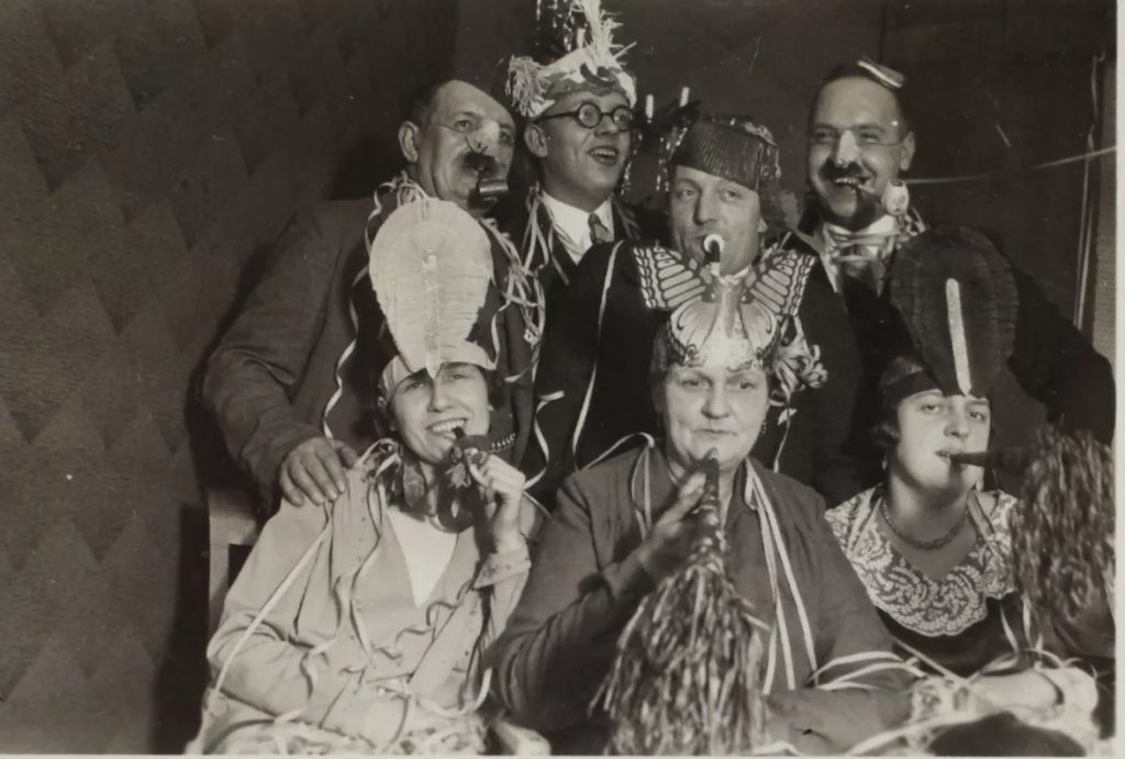 1930s vintage photo of a group of people celebrating New Years Eve in party hats and streamers