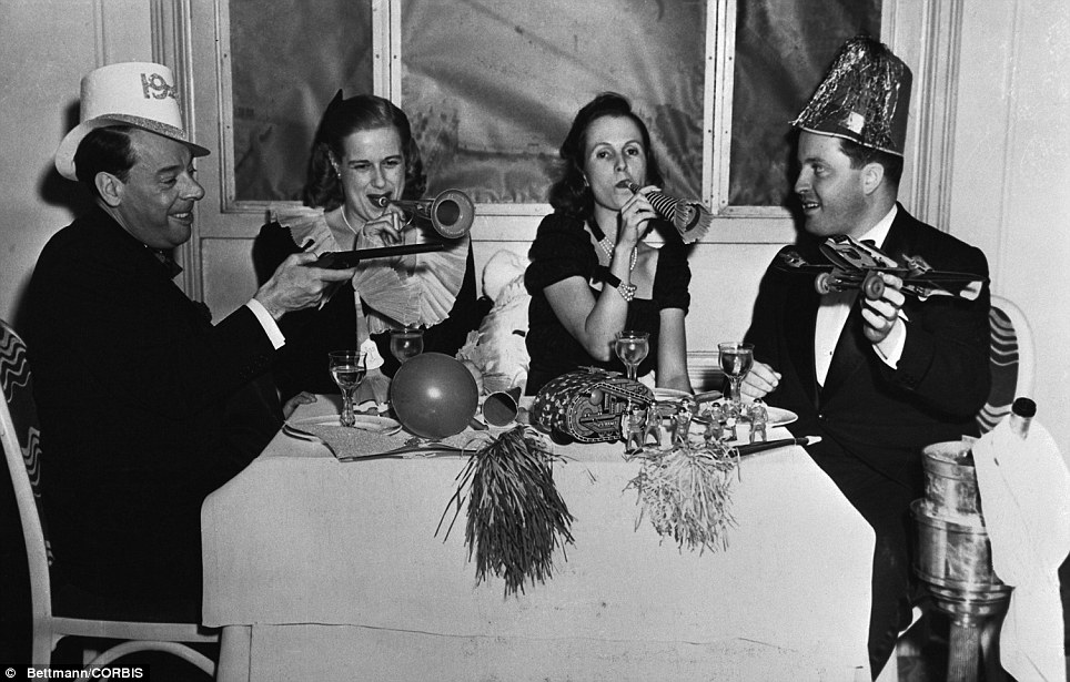 1940s vintage photo: Bring in the noise: Four diners give an enthusiastic welcome to the New Year at the Club Versailles in 1941