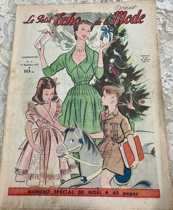 1950s vintage magazine: Le Petit Echo de la Mode Dec 1950 a fashion and sewing magazine for women featuring illustrations of women. girls & boys around the Christmas tree in 1950s fashions on the cover. 