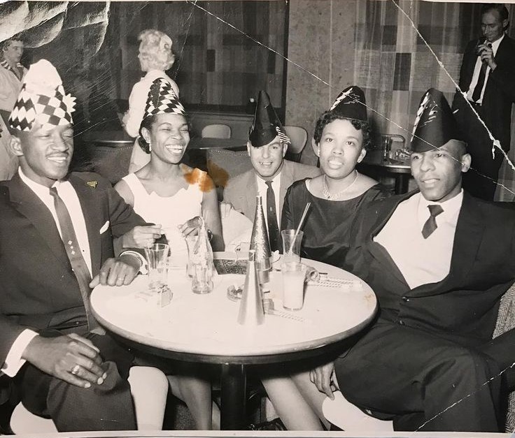 1950s / 1960s vintage photo of Black Men and Black Women wearing party hats celebrating New Years Eve. 